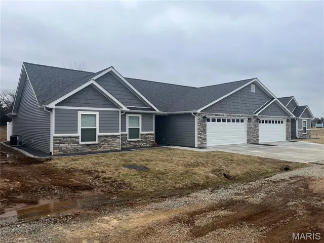 Craftsman inspired home with stone siding, driveway, an attached garage, and roof with shingles