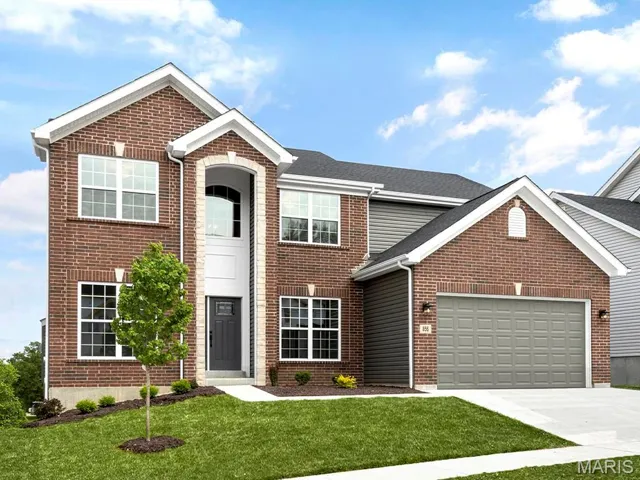 View of front of home with a front lawn and a garage