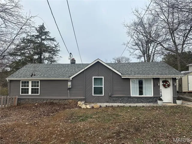 View of front of home featuring roof with shingles and a chimney