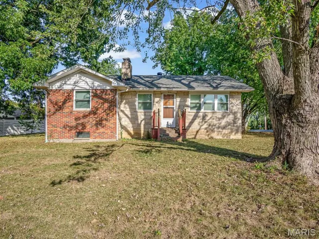 Single story home with a front lawn, brick siding, and a chimney