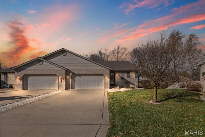 Ranch-style house featuring concrete driveway, a garage, brick siding, and a front lawn