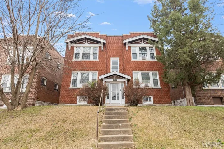 Traditional home with brick siding and a front lawn