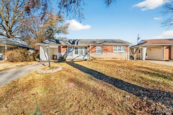Ranch-style home featuring a carport, driveway, brick siding, a front lawn, and a porch
