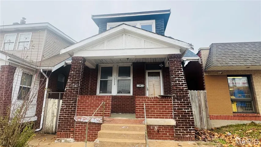 View of front facade with a porch and brick siding