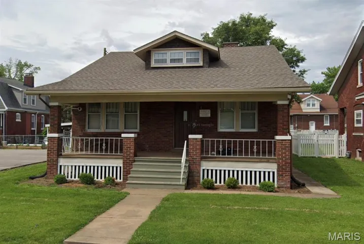 Bungalow featuring covered porch, brick siding, and a shingled roof