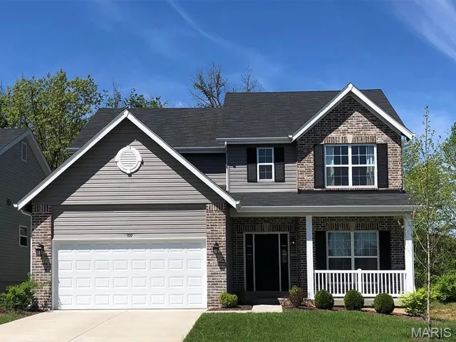 View of front of property with a garage and a porch