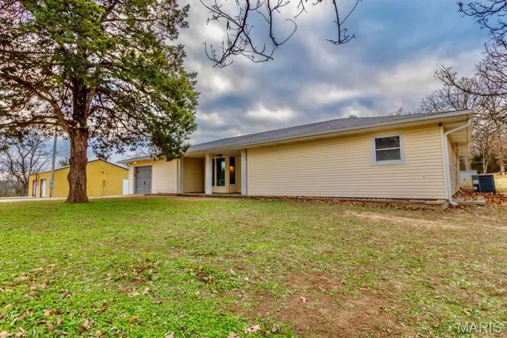 Ranch-style house with a garage and a front lawn