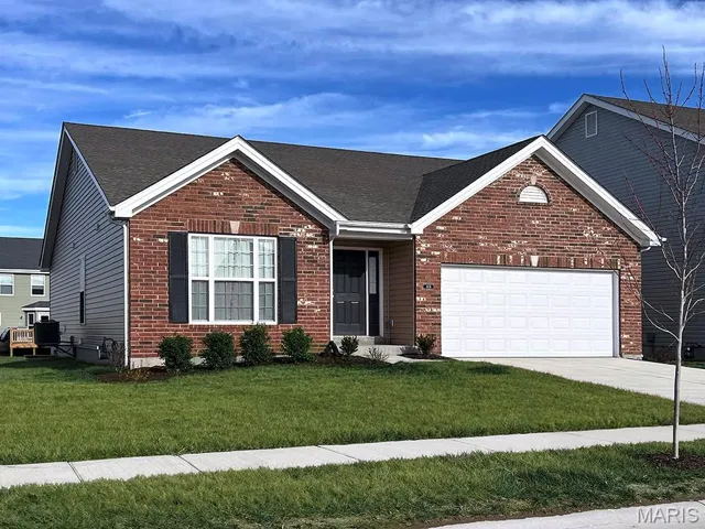 View of front of house featuring a garage and a front lawn