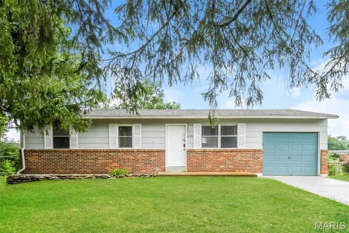 Single story home with a front yard, concrete driveway, brick siding, and a garage