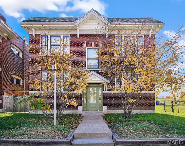 View of front of home featuring brick siding and a tiled roof