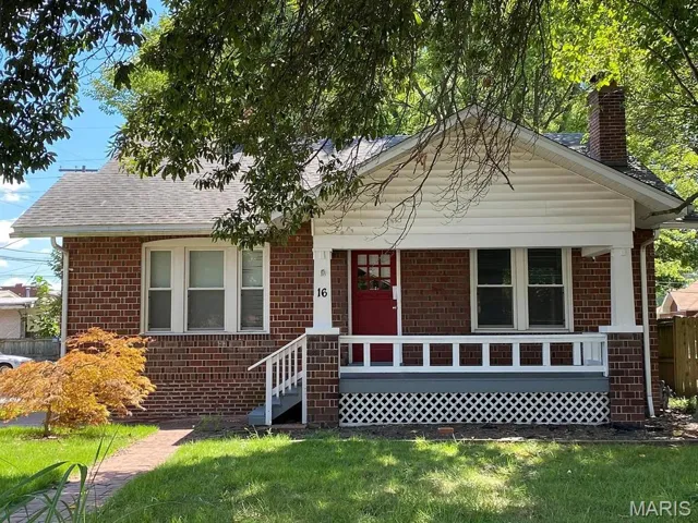 Bungalow-style home with brick siding, covered porch, a chimney, and a shingled roof