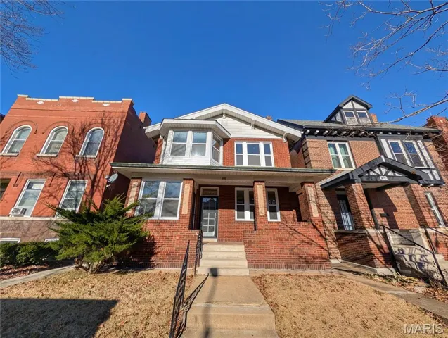 View of front of home with brick siding and a porch