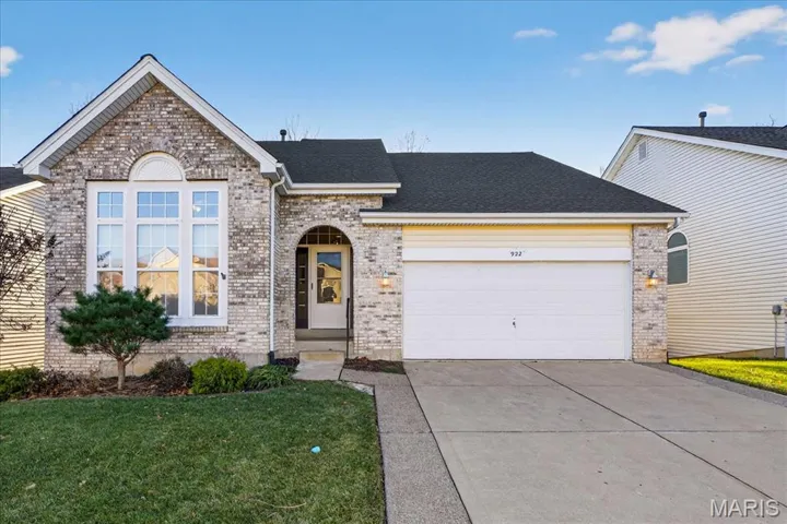 View of front of property with brick siding, a shingled roof, driveway, a front lawn, and a garage