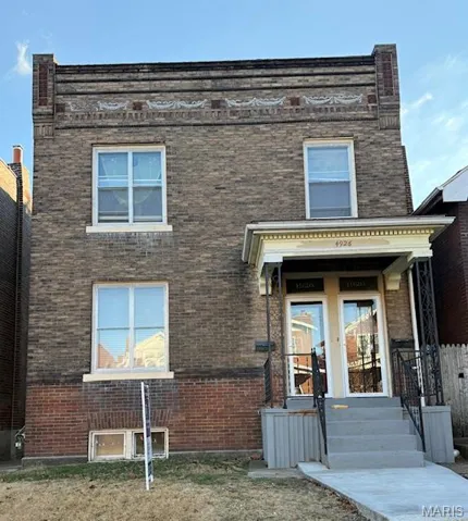 View of front of house featuring brick siding and french doors