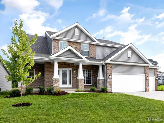 View of front facade with covered porch, a front lawn, concrete driveway, roof with shingles, and brick siding