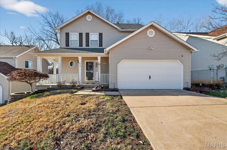 Traditional home with covered porch, concrete driveway, an attached garage, and roof with shingles