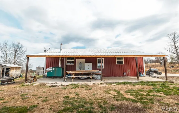 Back of house featuring board and batten siding and a patio