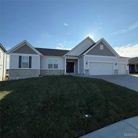 Craftsman inspired home with stone siding, a front yard, driveway, and an attached garage