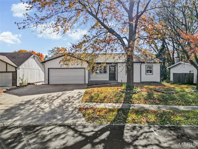 Ranch-style home featuring concrete driveway and an attached garage