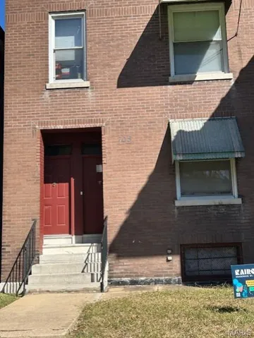 Entrance to property featuring brick siding