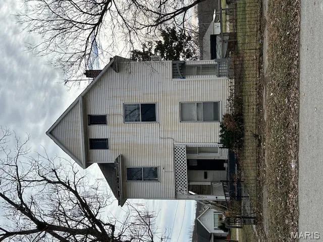 View of front of property featuring a chimney, a fenced front yard, and covered porch