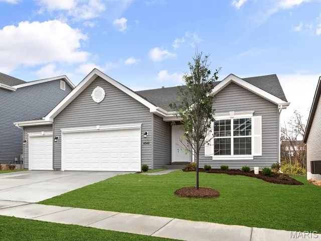Single story home with concrete driveway, a front lawn, a garage, and roof with shingles