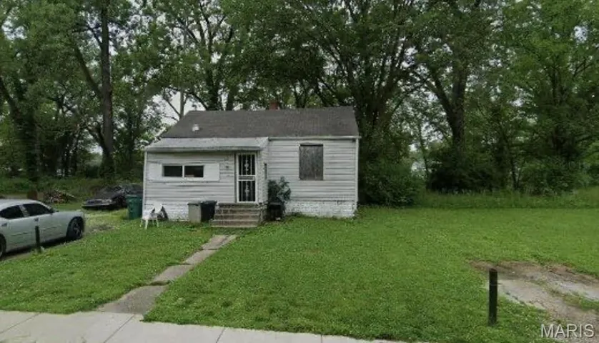 View of front facade featuring a front lawn, entry steps, and view of scattered trees