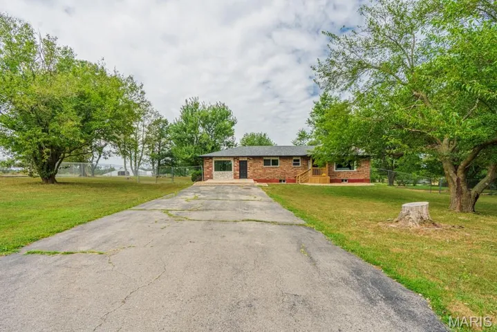 Single story home featuring asphalt driveway and brick siding