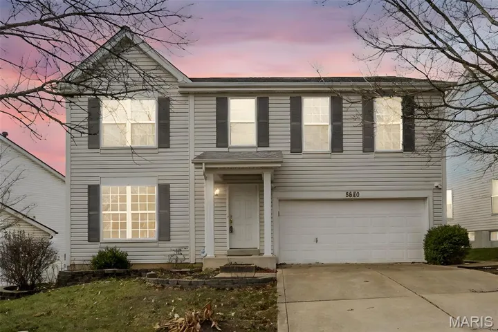 View of front facade featuring concrete driveway and an attached garage