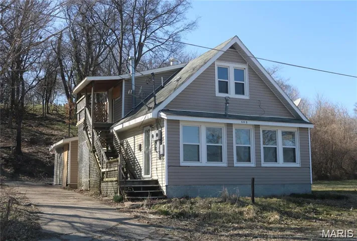 View of front of house with stairway and asphalt driveway