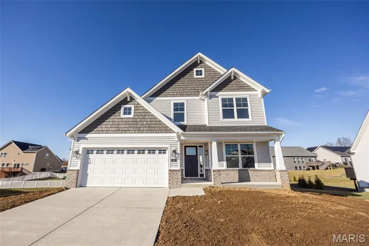 Craftsman-style house featuring a porch, concrete driveway, and brick siding