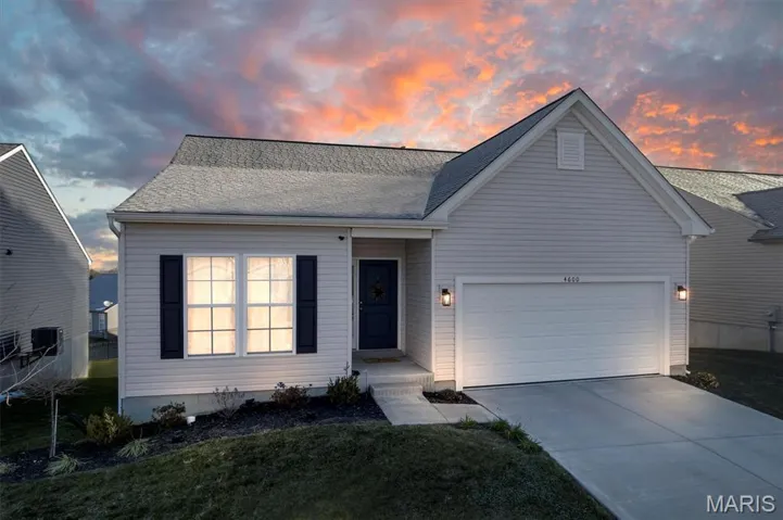 View of front facade with concrete driveway, a garage, a yard, and a shingled roof