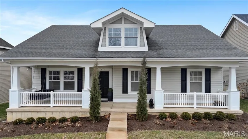 View of front of property with a shingled roof and covered porch