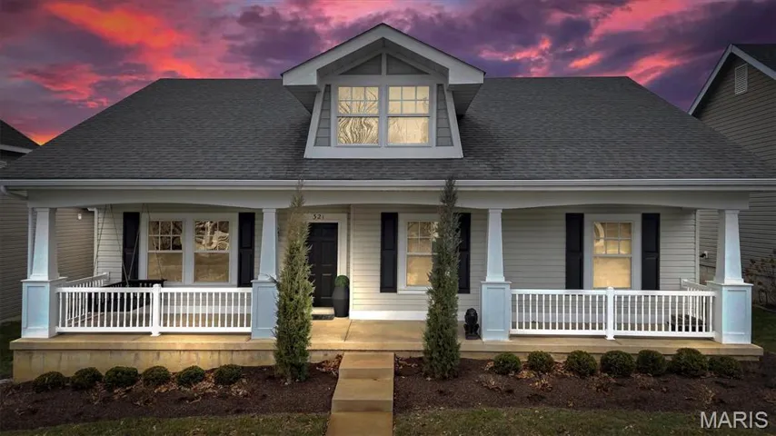 View of front of home with a shingled roof and a porch