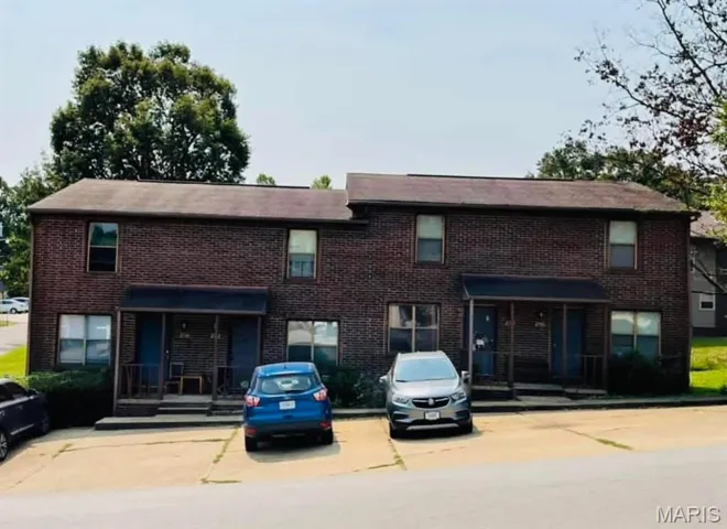 View of property with uncovered parking