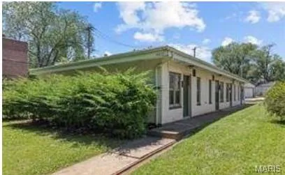 View of side of home with a yard