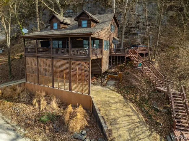 Back of house featuring stairway and a wooden deck