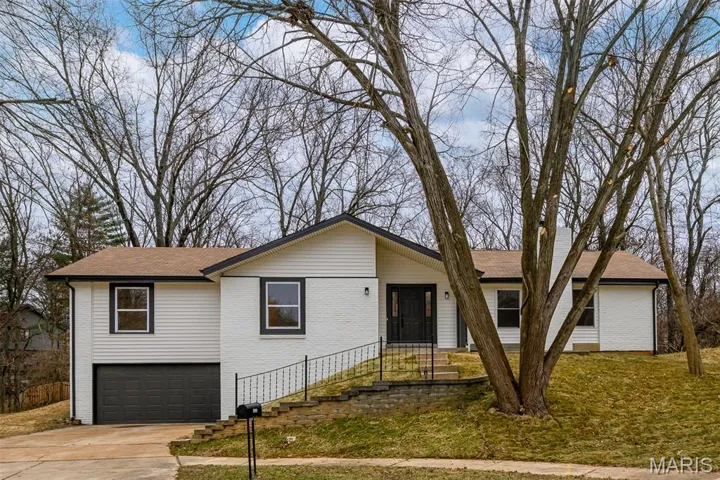 Ranch-style home with concrete driveway, brick, vinyl siding, and a shingled roof