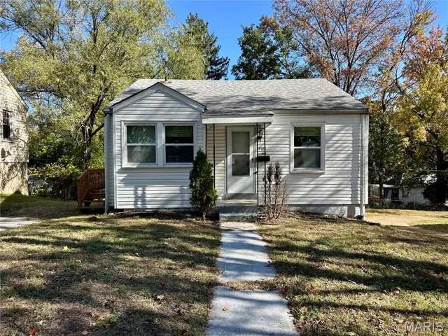 Bungalow-style home featuring a front lawn and roof with shingles