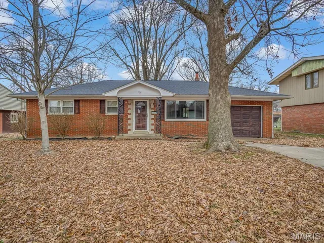 Ranch-style house featuring brick siding, a garage, a chimney, driveway, and a shingled roof