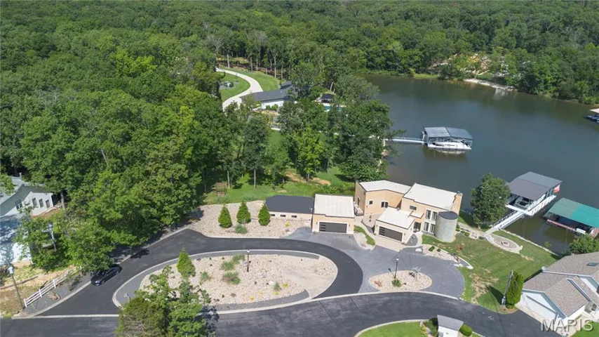 Aerial view of property's location with a large body of water and a heavily wooded area