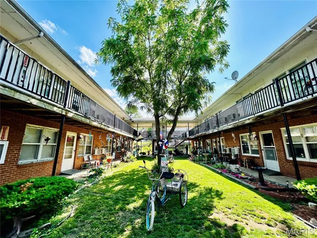 Surrounding community featuring a patio, a lawn, and a balcony