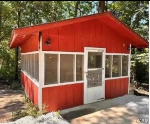 View of outdoor structure featuring a sunroom