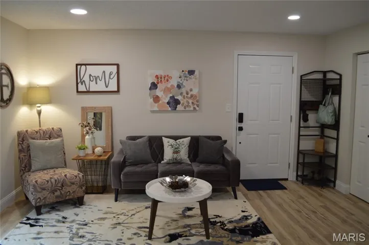 Living area with light wood-style flooring and recessed lighting