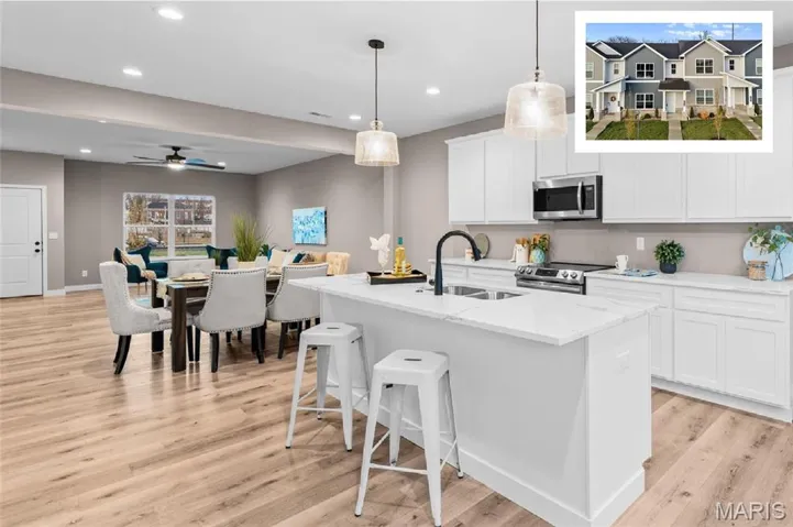 Kitchen featuring hanging light fixtures, white cabinets, open floor plan, stainless steel appliances, and recessed lighting