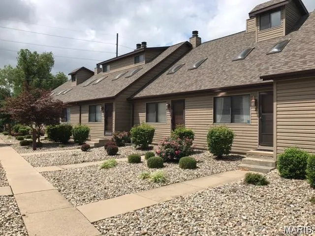 View of front of home featuring a chimney and a shingled roof