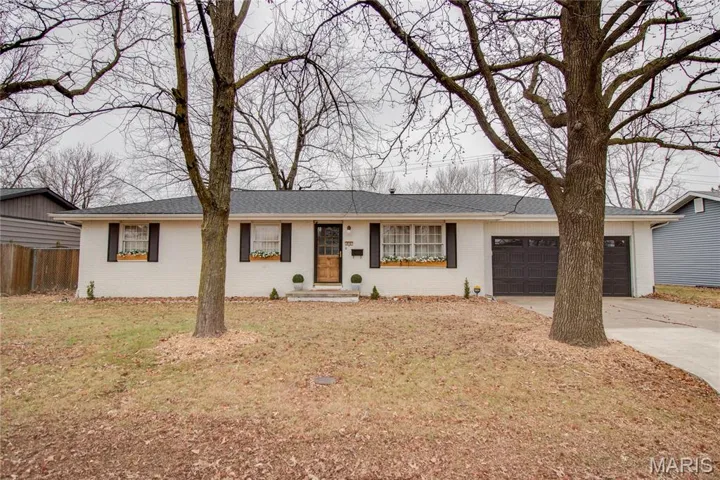 Single story home with concrete driveway, brick siding, a garage, and a shingled roof