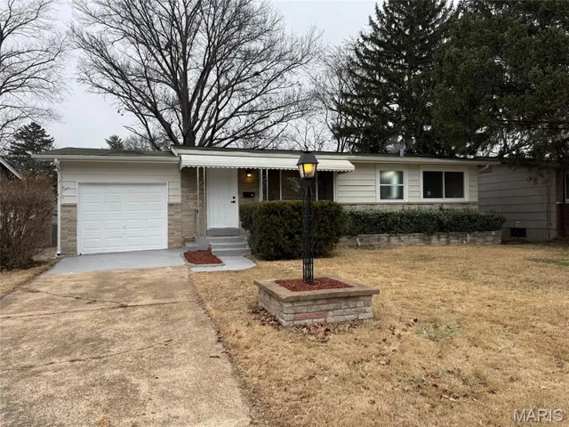 Ranch-style home with driveway, a garage, a front lawn, and a porch