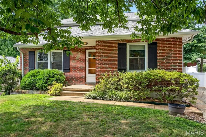 View of front of property with brick siding and roof with shingles