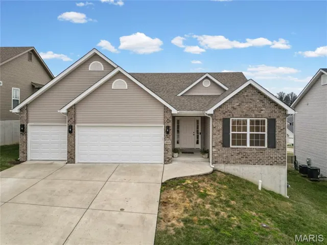 Ranch-style house with brick siding, concrete driveway, a garage, a shingled roof, and a front lawn